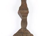 an old metal object hanging on a white wall