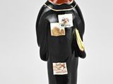 a figurine of a man with a bird on his head