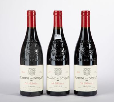 trois bouteilles de vin rouge posées sur une table blanche
