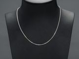 a black mannequin with a silver chain on it