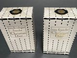 two white boxes with black and white designs on them sitting on a table