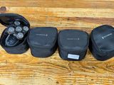 three black cases sitting on top of a wooden table next to a pair of headphones