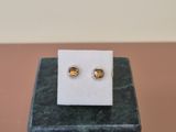 a pair of earrings sitting on top of a black box