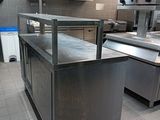 a large stainless steel counter in a kitchen with pots and pans on it