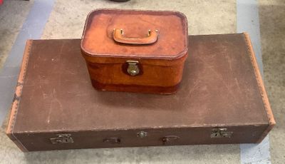 a brown suitcase sitting on top of a brown piece of luggage
