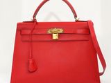 un sac à main en cuir rouge muni d'un fermoir doré sur la poignée