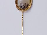 a close up of a gold and white broochle on a stick