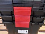 a close up of a stack of black and red boxes on a pallet