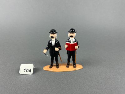two figurines of two men dressed in black and white