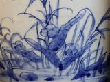 a blue and white vase with a plant in it
