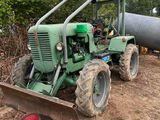un tracteur qui est à l'arrêt dans la terre, près d'un tuyau