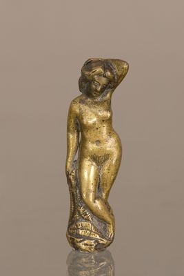 une photo d'une figurine en or représentant une femme, posée sur une table
