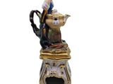 an image of a figurine of a woman sitting on top of a teapot