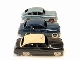 several toy cars are lined up in a row on a white surface