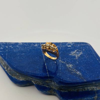 a close up of a gold ring on a blue stone