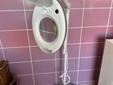 une lampe blanche posée sur un pied dans une salle de bains