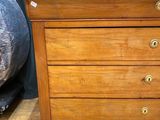 a wooden chest of drawers with a marble top