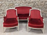 two red and white chairs sitting next to each other in front of a stone wall