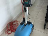 a blue machine that is on the floor next to a wall