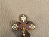 a close up of a small cross on a leather surface