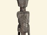 a wooden statue of a man sitting on a stool