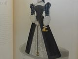 an open book with a drawing of a woman in a black dress