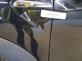 a man that is standing next to a car with a sticker on it