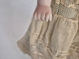 a close up of a doll wearing a dress and a hat