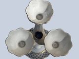 a white vase with three white flowers on it