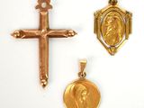 deux croix en or et une médaille en or sur fond blanc