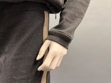 a female mannequin wearing a gray sweater and a brown skirt