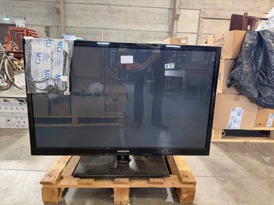 un téléviseur à écran plat posé sur une palette dans un entrepôt