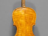 an old violin with a wooden back and bow on a gray background