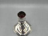 an image of a silver candle holder with a red stone in it