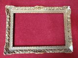 a close up of a picture frame on a red surface