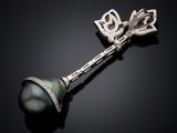 a close up of a black pearl and diamond broochle on a black surface