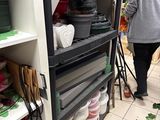 a woman that is walking through a store with many items