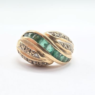 une image d'un gros plan d'une bague en or avec une pierre verte