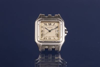 an image of a silver watch on a blue surface