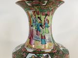 a vase with a painting on it sitting on a table