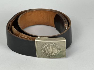 ceinture en cuir avec une boucle argentée sur un fond blanc