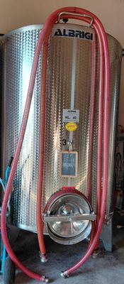 a large metal tank with a red hose attached to it