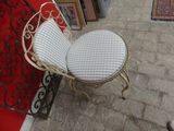 a chair that has two cushions on it in front of a red wall
