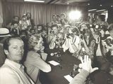 black and white photograph of a group of people sitting around a table