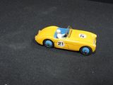 a yellow toy car that is sitting on a black surface
