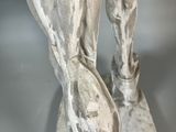statue of a man holding a tennis racquet on top of a tennis court