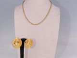 un mannequin blanc portant un collier et des boucles d'oreilles en or