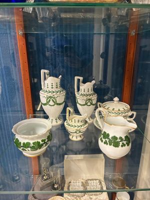 une vitrine en verre dans laquelle sont exposées de nombreuses pièces de poterie