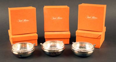 trois bols argentés avec des carrés orange sur un fond noir