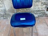 a blue chair that is sitting on a tile floor